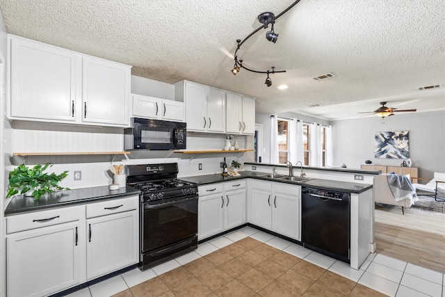 kitchen featuring visible vents, open shelves, dark countertops, a sink, and black appliances