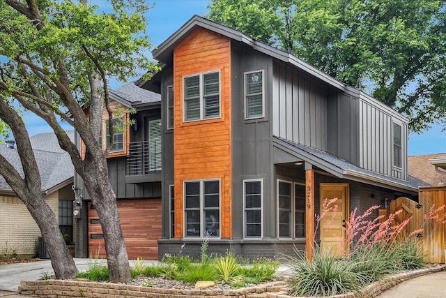3219 Bryan St, Dallas, TX 75204 - view of front of home with board and batten siding, fence, a balcony, and driveway