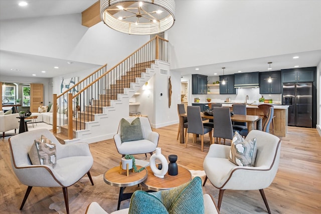 3219 Bryan St, Dallas, TX 75204 - living area featuring high vaulted ceiling, stairs, light wood-type flooring, recessed lighting, and a chandelier
