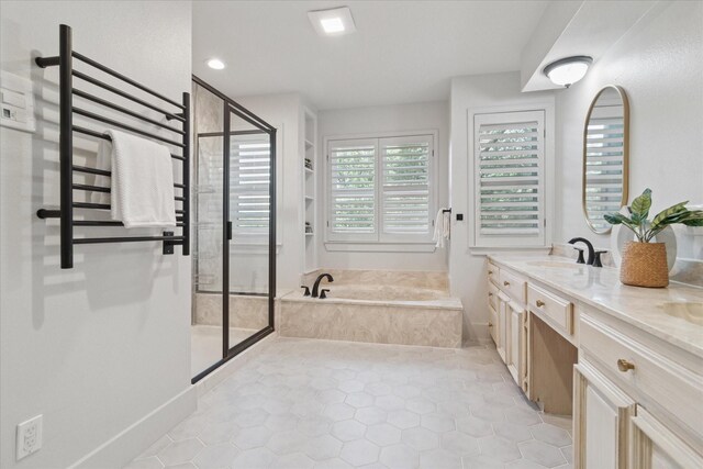 bathroom featuring a sink, double vanity, radiator, a bath, and a stall shower
