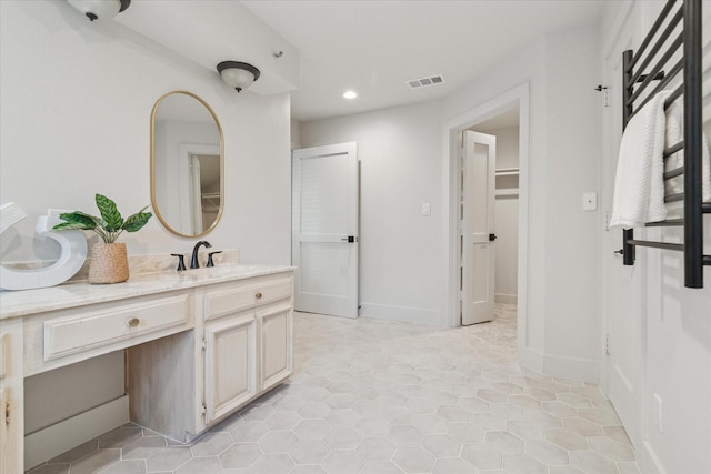 bathroom with visible vents, vanity, a walk in closet, recessed lighting, and tile patterned floors