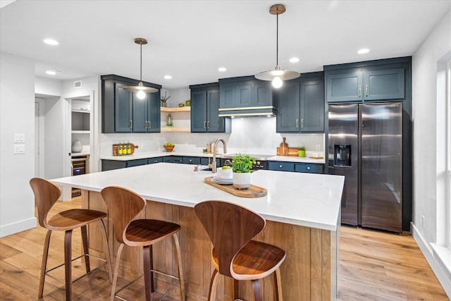 3219 Bryan St, Dallas, TX 75204 - kitchen with stainless steel fridge, light wood-style floors, open shelves, baseboards, and recessed lighting