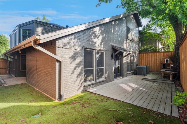 back of house with brick siding, fence, a wooden deck, and cooling unit