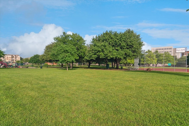 view of yard featuring fence and a tennis court