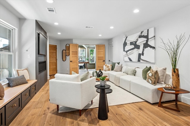 3219 Bryan St, Dallas, TX 75204 - living room featuring recessed lighting, light wood finished floors, and a glass covered fireplace