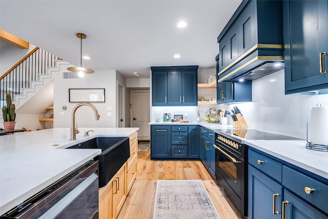 kitchen with a sink, high end stove, blue cabinets, and dishwasher