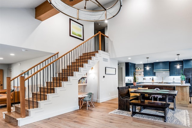 interior space with baseboards, a high ceiling, recessed lighting, and wood finished floors