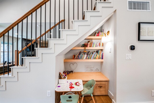 interior space featuring baseboards, wood finished floors, and visible vents