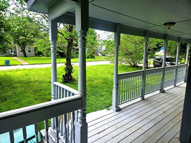 deck featuring covered porch and a yard