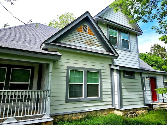 rear view of property featuring roof with shingles