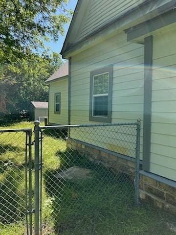 view of property exterior with fence and a gate