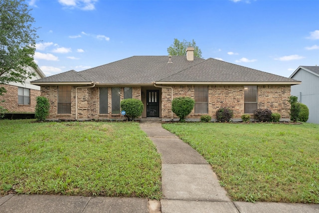 single story home with brick siding, a chimney, roof with shingles, and a front lawn