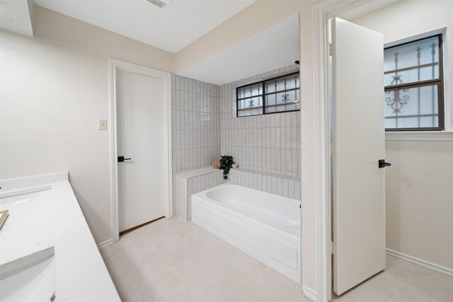 full bathroom with double vanity, baseboards, tile patterned floors, a sink, and shower / washtub combination