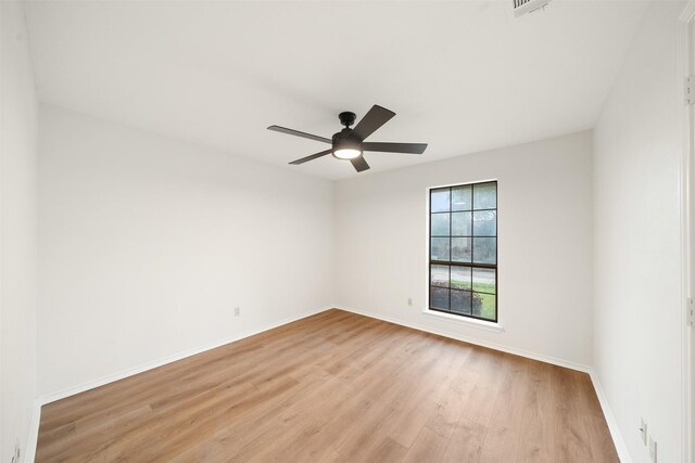 spare room with baseboards, a ceiling fan, and light wood-style flooring