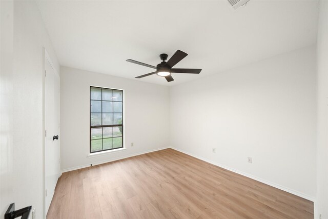 spare room featuring light wood-style floors, baseboards, ceiling fan, and visible vents