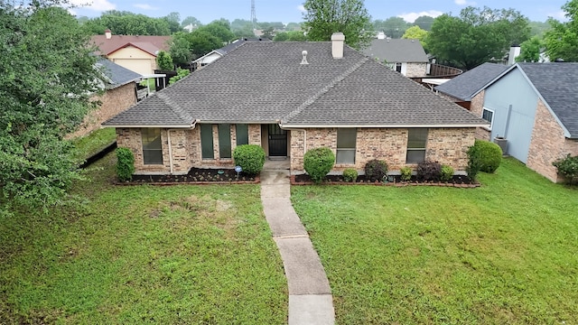 view of front of property with brick siding, a front lawn, and roof with shingles