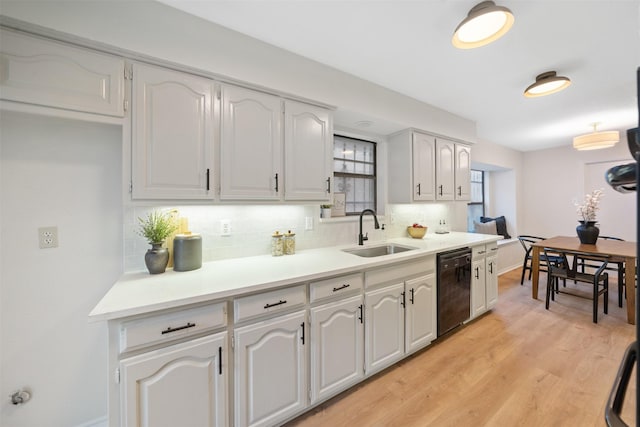 kitchen with decorative backsplash, white cabinetry, a sink, light wood-style flooring, and dishwasher