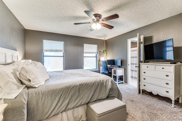 bedroom with ensuite bathroom, a textured ceiling, carpet, and a ceiling fan