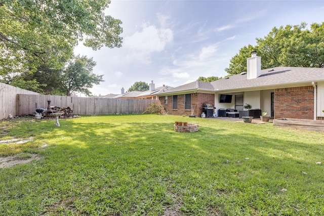 view of yard with a patio, a fenced backyard, and an outdoor living space with a fire pit