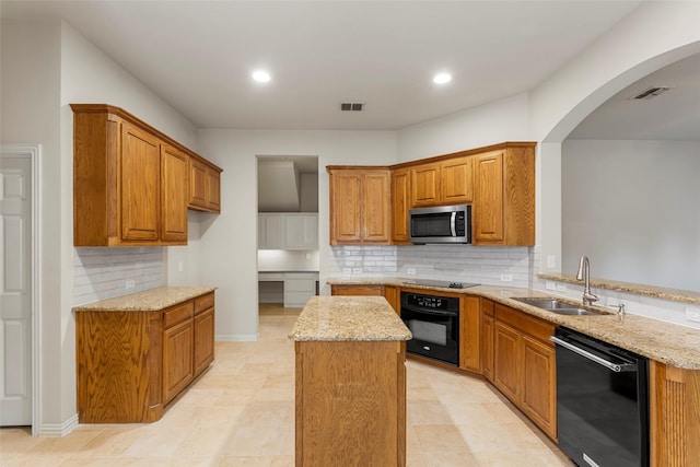 kitchen with brown cabinets, visible vents, a sink, and black appliances