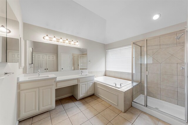 bathroom with tile patterned flooring, a sink, a garden tub, and a shower stall