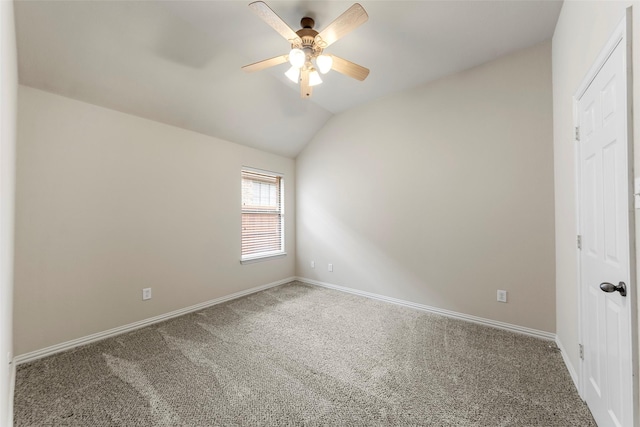 empty room featuring baseboards, carpet, ceiling fan, and lofted ceiling