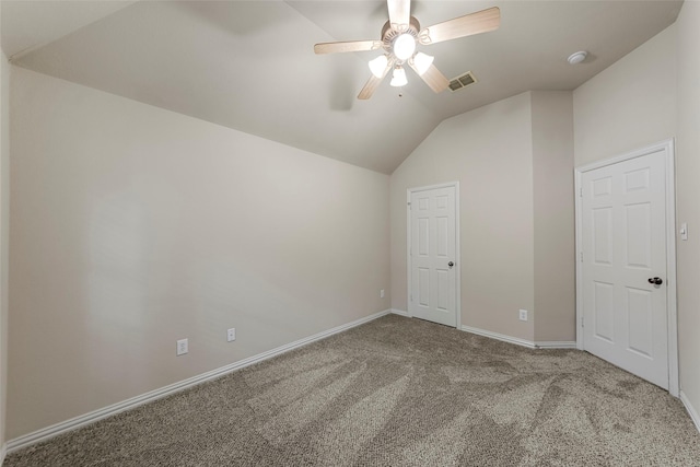 interior space with ceiling fan, visible vents, vaulted ceiling, baseboards, and carpet
