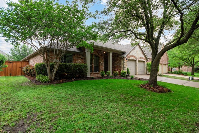 single story home featuring fence, an attached garage, a front lawn, brick siding, and driveway