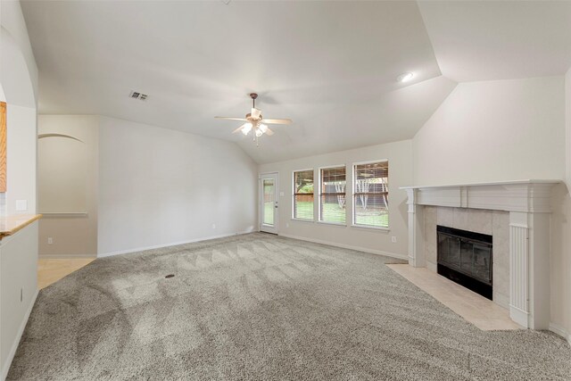 unfurnished living room featuring ceiling fan, visible vents, a fireplace, vaulted ceiling, and light carpet