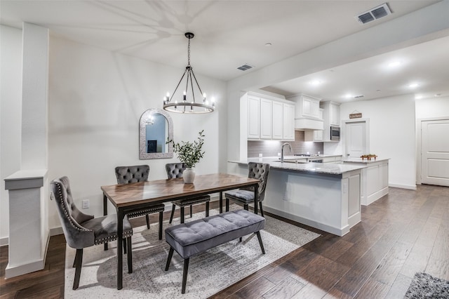 dining room with an inviting chandelier, dark wood-type flooring, recessed lighting, and visible vents