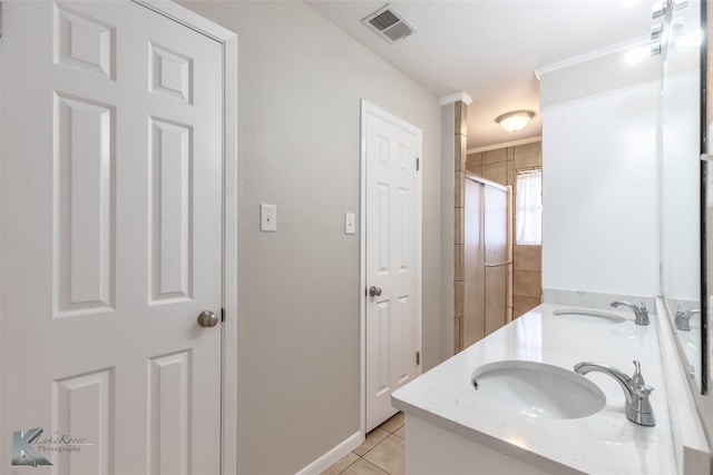 bathroom with a sink, tile patterned floors, double vanity, and visible vents