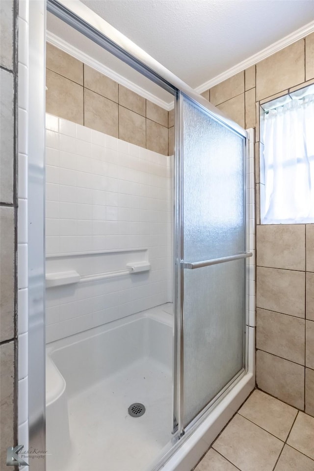 bathroom featuring tile patterned floors, a shower stall, and ornamental molding