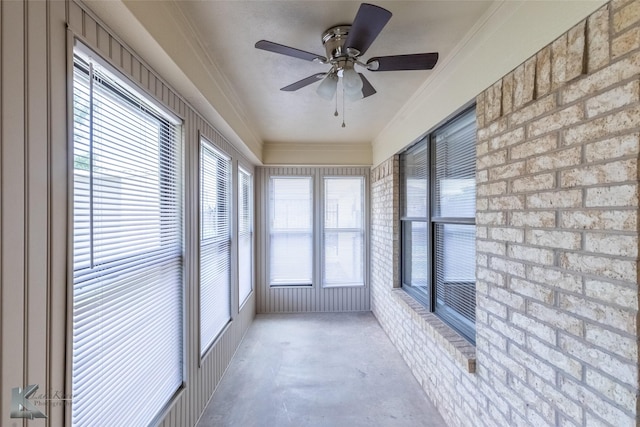 unfurnished sunroom with ornamental molding, concrete flooring, and a healthy amount of sunlight