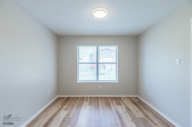 empty room featuring baseboards and light wood finished floors