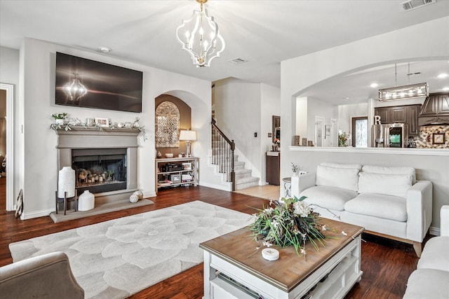 11308 Hubbard Creek Dr, Frisco, TX 75036 - living area featuring arched walkways, wood finished floors, a fireplace with raised hearth, and recessed lighting