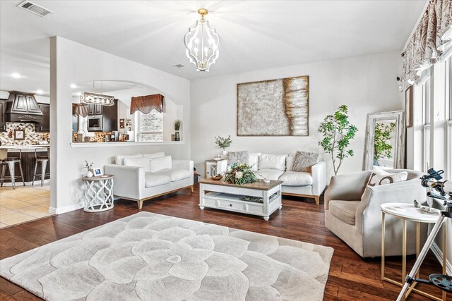 11308 Hubbard Creek Dr, Frisco, TX 75036 - living area with a chandelier, arched walkways, and wood finished floors