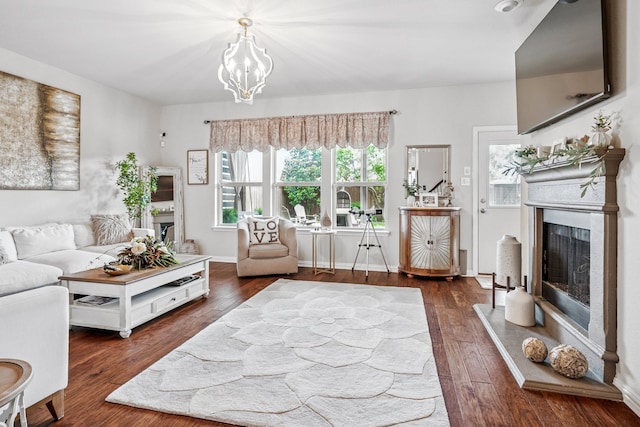 11308 Hubbard Creek Dr, Frisco, TX 75036 - living room with a fireplace with raised hearth, wood finished floors, and a chandelier
