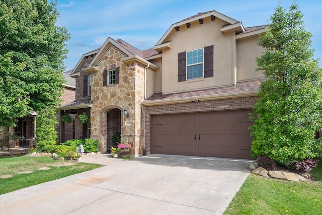 11308 Hubbard Creek Dr, Frisco, TX 75036 - view of front of property with a garage, stone siding, driveway, stucco siding, and a front yard