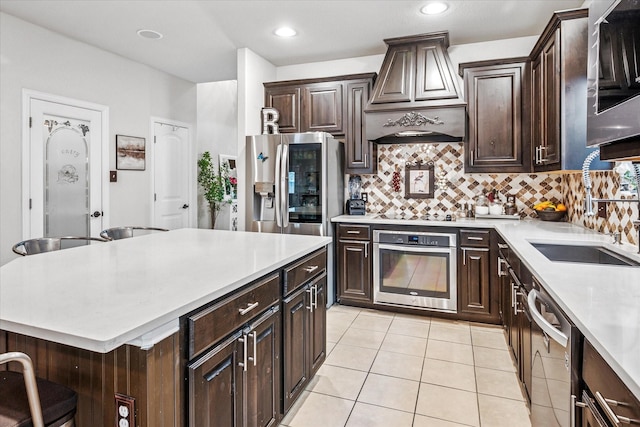 11308 Hubbard Creek Dr, Frisco, TX 75036 - kitchen with appliances with stainless steel finishes, premium range hood, a sink, light countertops, and backsplash