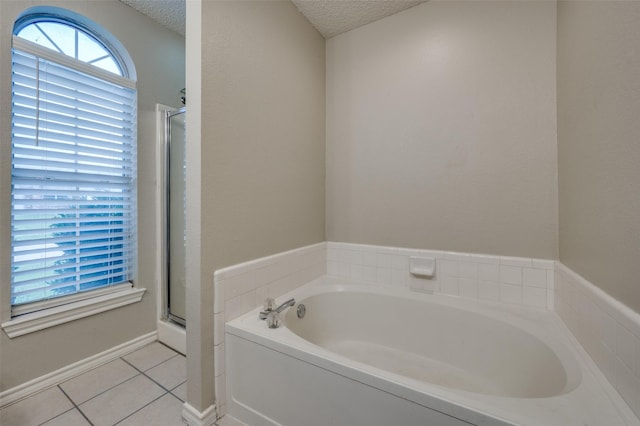 2909 Chisholm Trl, Corinth, TX 76210 - full bath featuring tile patterned flooring, a garden tub, a textured ceiling, a stall shower, and baseboards