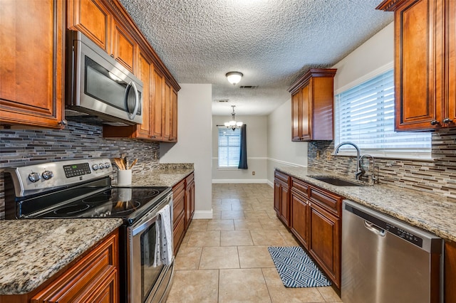 2909 Chisholm Trl, Corinth, TX 76210 - kitchen with appliances with stainless steel finishes, a sink, decorative backsplash, light tile patterned floors, and baseboards