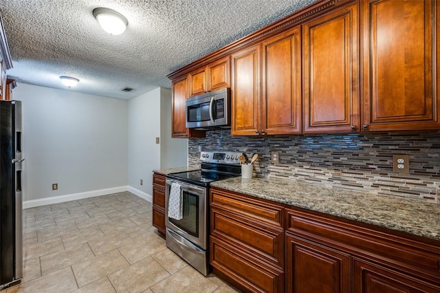 2909 Chisholm Trl, Corinth, TX 76210 - kitchen with appliances with stainless steel finishes, baseboards, decorative backsplash, a textured ceiling, and light stone countertops