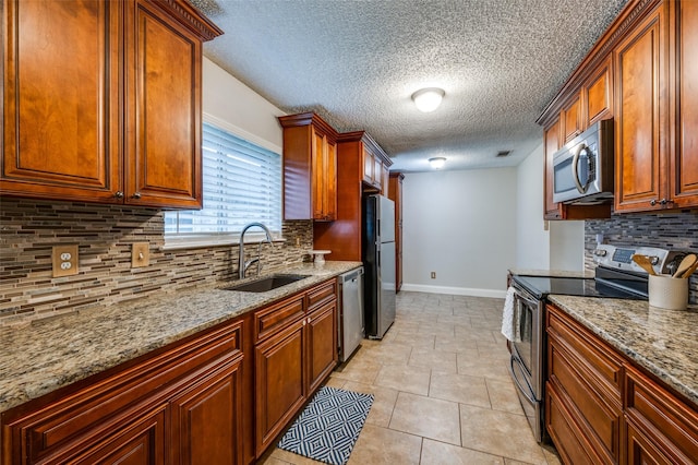 2909 Chisholm Trl, Corinth, TX 76210 - kitchen with stainless steel appliances, a sink, baseboards, backsplash, and a textured ceiling