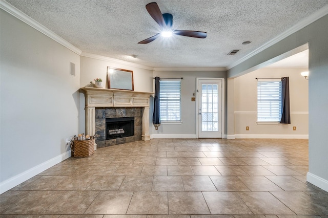 2909 Chisholm Trl, Corinth, TX 76210 - unfurnished living room featuring ceiling fan, a textured ceiling, plenty of natural light, a tile fireplace, and ornamental molding