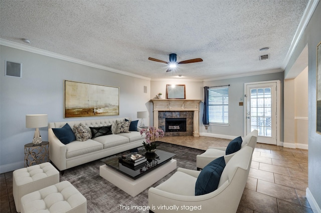 2909 Chisholm Trl, Corinth, TX 76210 - living room with a tile fireplace, ornamental molding, a ceiling fan, baseboards, and a textured ceiling