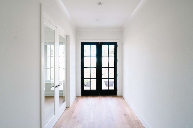 doorway to outside with french doors, light wood-style floors, and baseboards