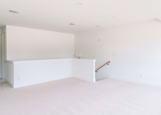 empty room with baseboards, light carpet, recessed lighting, and visible vents