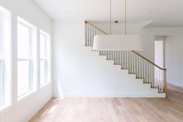 staircase featuring baseboards and wood finished floors