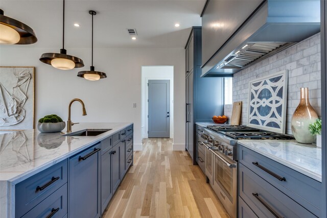 kitchen featuring double oven range, visible vents, tasteful backsplash, a sink, and custom exhaust hood
