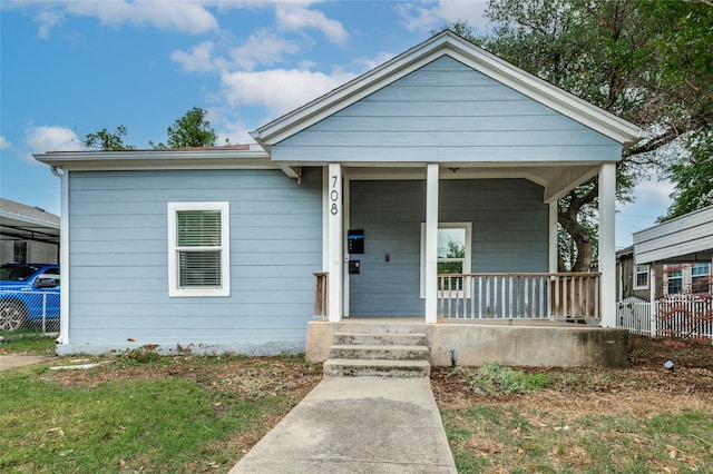 bungalow-style home with a porch and fence